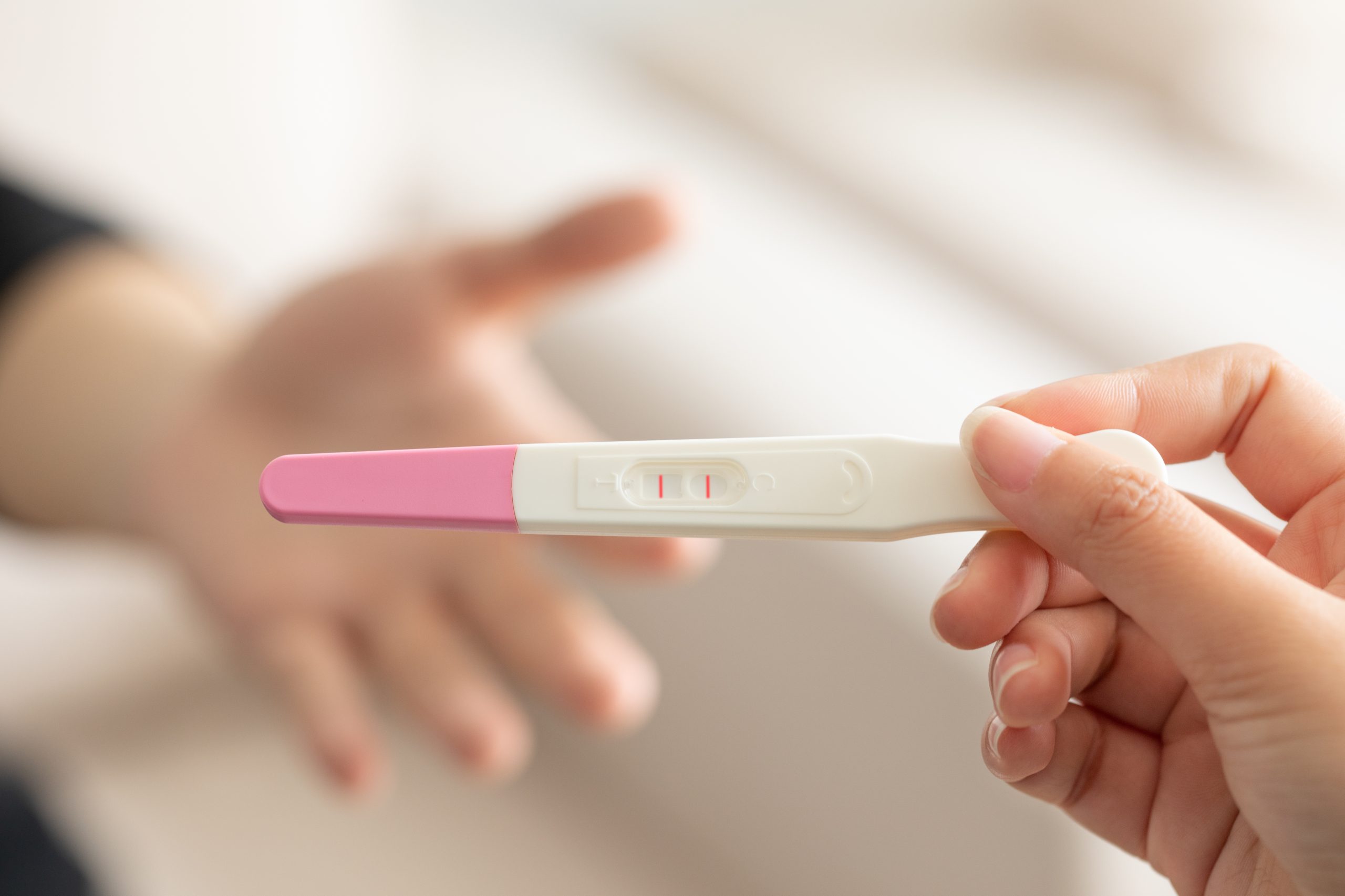 Тест на беременность в руках у девушки. Тест на беременность. Тест для беременных. Женская рука с тестом на беременность. Положительный тест на беременность.